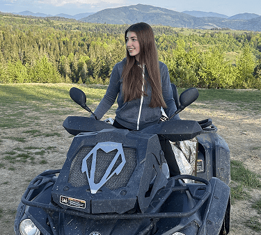 a woman sitting on a quad with a helmet on