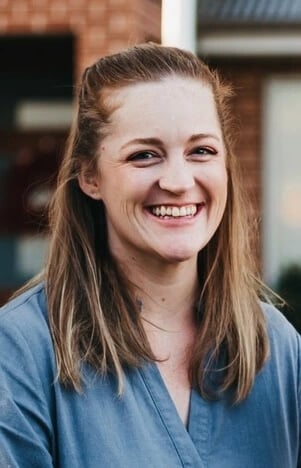 a smiling image of Amy Keeble, coach at Next Chapter Coaching, with long hair and a blue shirt