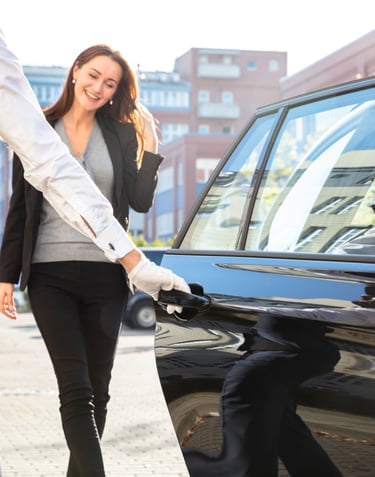 Voiturier ouvrant la porte au client avec professionnalisme et discrétion.