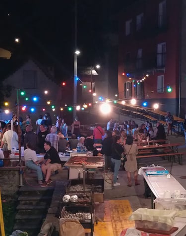 a group of people sitting at tables with lights on, festa campestre Menzonio
