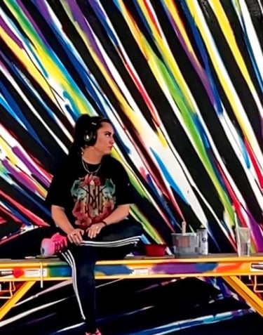 kamile in front of colorful feather mural