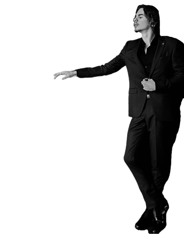 a man in a suit and shoes standing in front of a black background