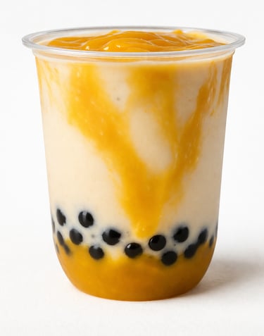 Mango bubble tea smoothie with black tapioca pearls and fruit puree in a clear plastic cup.