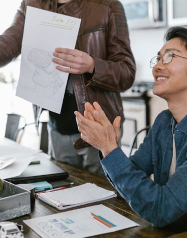 a man in a blue shirt is holding a paper with a paper clipping on