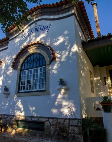 Historic Vila Belita architecture with arched windows and terracotta roof in sunlight.