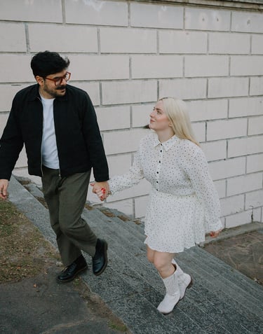 Pareja tomada de la mano subiendo una escalera