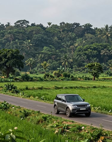 A luxury SUV driving through a picturesque rural road in South Asian / Indian landscape near Lakhisarai, with lush green fields and deep forest green trees in the background.