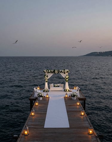 A wide-angle landscape shot of a Turkish wedding ceremony at dusk on a Bodrum pier, glowing lanterns, elegant white decor, deep slate grey sea in the background.