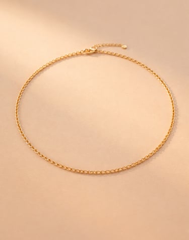 Collana dorata in ottone placcato oro su sfondo chiaro