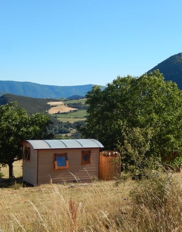 La roulotte, avec sa douche extérieure, blottie dans les arbres