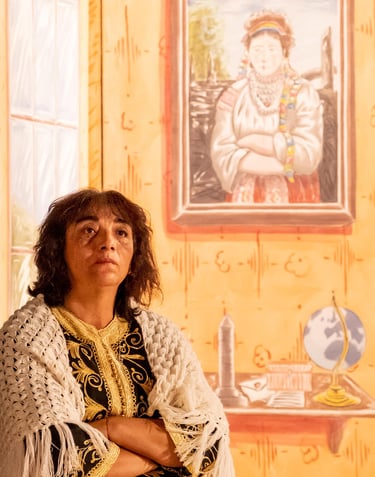 Actress looking off camera to the right with a picture on the wall in exactly the same pose