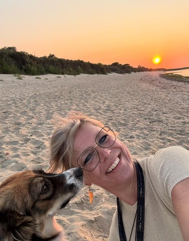 a woman is smiling and a dog is kissing her