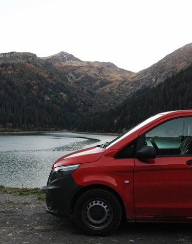 a red van parked on a mountain side