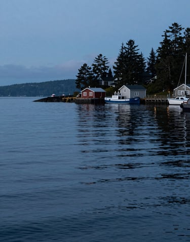 An evocative evening photograph of a calm harbor in the North American Pacific Northwest, with soft light blue and dark blue reflections on the water and a sense of quiet adventure.