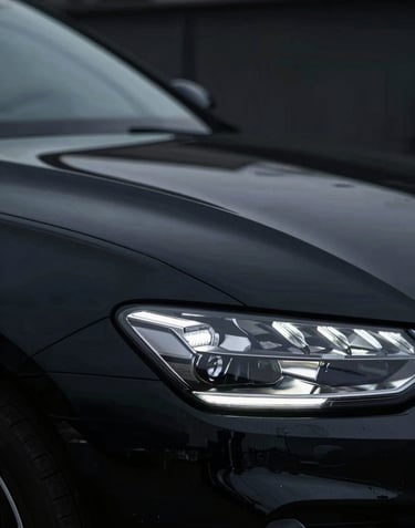 A high-gloss black car panel with a perfect reflection of a specialized LED light used by 'varilleros', showing zero imperfections. Dark, professional mood.