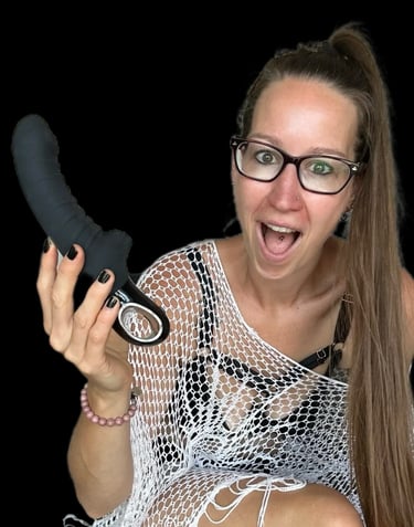 Pleasurelit Patricia holding the black Tiger Vibrator from Fun Factory.