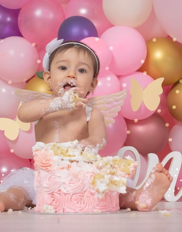 a baby girl sitting in front of a cake