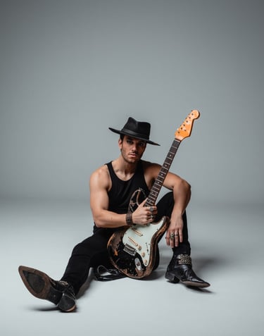 a vocalist in a hat with a guitar