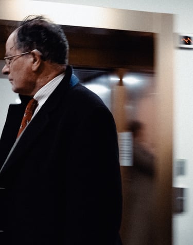 a man in a suit and tie walking through a hallway