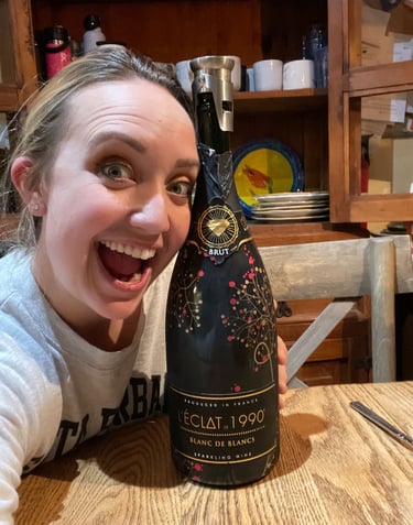 Danielle, 12/31/2022 hugging a Trader Joe's bottle of L'Eclat sparkling wine.