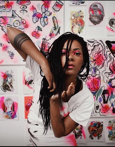 Artist with black braids posing in front of a wall of colorful street art and spray-painted illustrations.