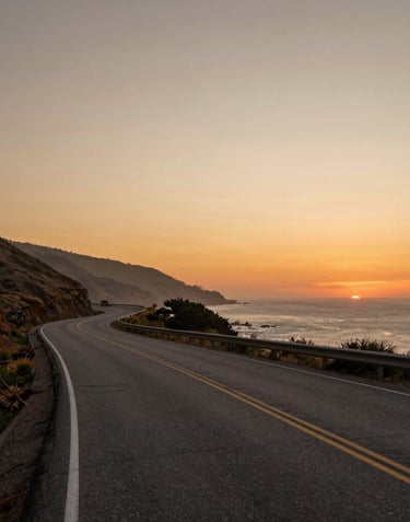 A soulful landscape photograph of a winding North American coastal road at sunset. The sky is a blend of soft beige and burnt orange. The composition is wide and peaceful, reflecting a trop rock and folk aesthetic.