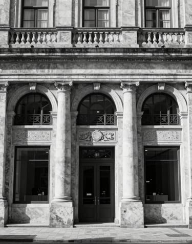Black and white shot of a classic stone facade of a Portuguese bank or corporate headquarters, representing stability and tradition.