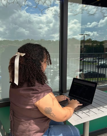 a woman sitting at a table with a laptop