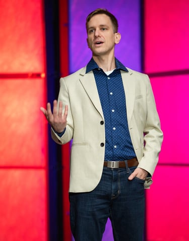 Remy stands on stage speaking