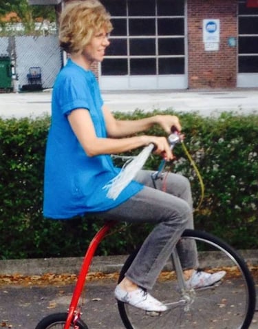 Image of author Dawn Davies riding a large front-wheel tricycle