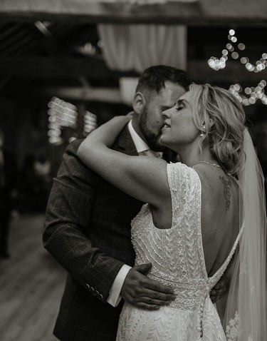 a bride and groom kissing in a barn wedding