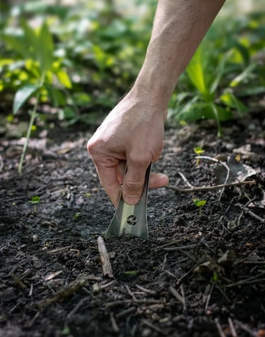 Hand pushing boglerco trowel into ground