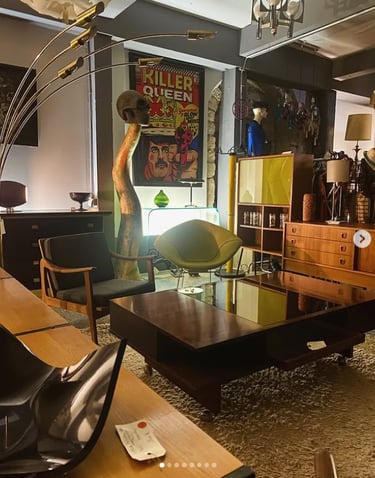 Salle d'exposition moderne du milieu du siècle avec des tables basses vintage, des fauteuils rétro e