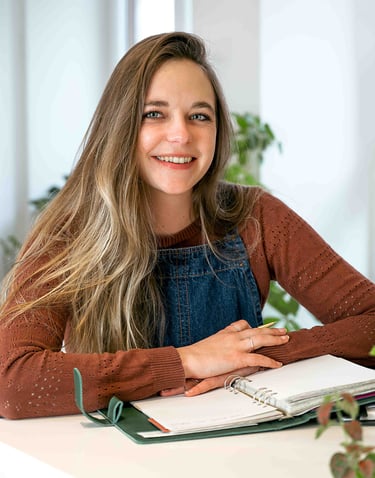 a woman sitting at a desk with a notebook