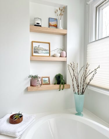 Modern bathroom alcove featuring light oak floating shelves with minimalist decor and indoor plants.