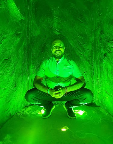 a man sitting in a tunnel with a green light