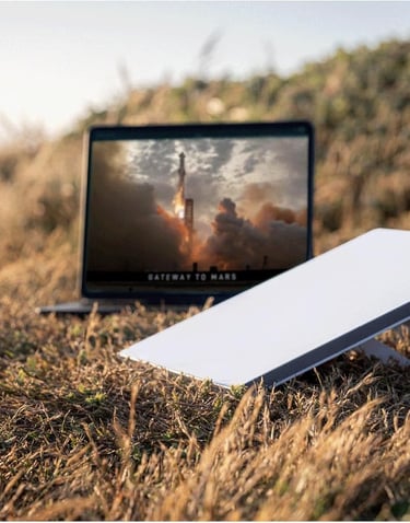 Portable Starlink satellite dish and laptop with high-speed internet in a remote outdoor field.