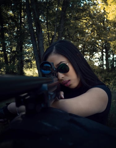 Mujer con rifle de francotirador apunta en un bosque con luz tenue