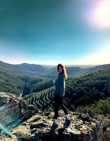 Woman smiling on mountain cliff with valley view, yoga and psychology counseling