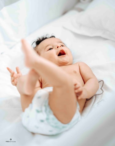 Smiling baby lying on bed – Fred Art Studio family session