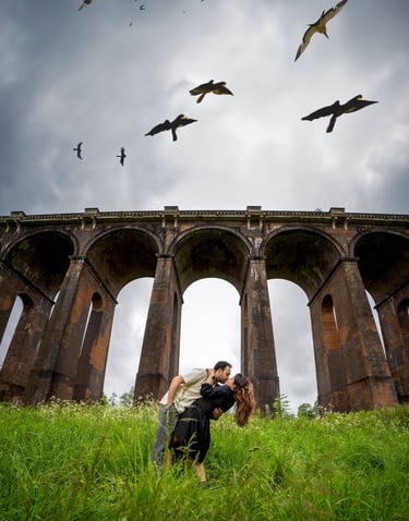 Couple kissing beneath a historic railway viaduct in Kent countryside, captured by Fred Art Studio.