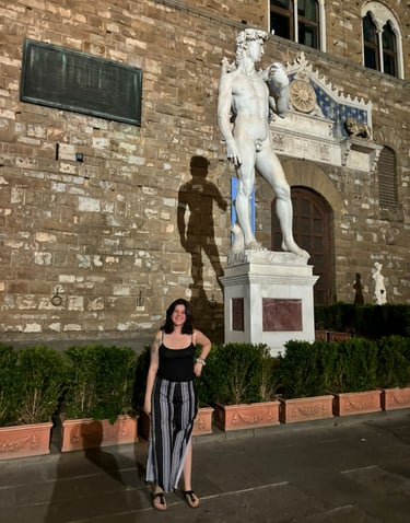 Profesora de italiano con la estatua del DAvid de Miguel Angel en Florencia