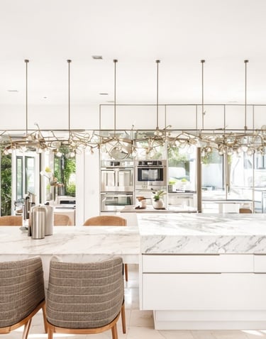 uma cozinha com bancada de mármore e cadeiras