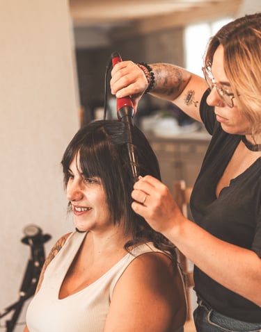 une femme se fait couper les cheveux par une coiffeuse