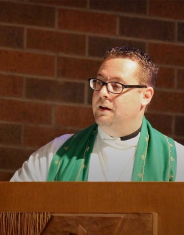 a pastor standing at a podium with a priest