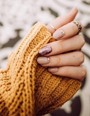 a woman's hand holding a gold ring