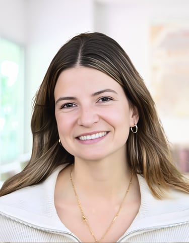 A smiling professional woman with long brown hair wearing a white jacket and gold jewelry.