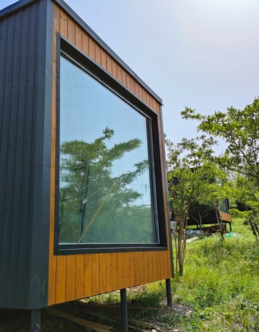 a house with a large window and a tree in the background