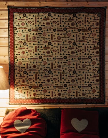 coussin rouge et tenture style montagne au mur
