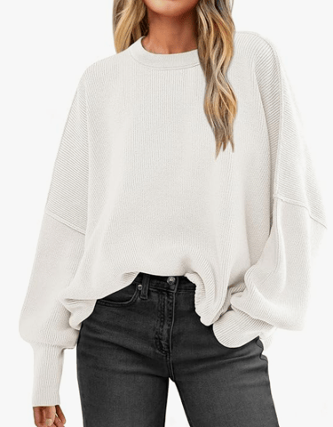 a woman wearing a white sweater and black jeans